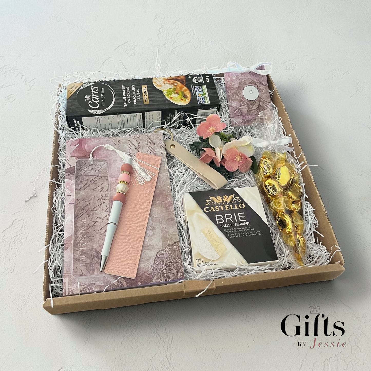 unique gift box with cheese, crackers, candy, tea a puzzle book, handmade pen