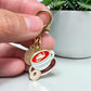 Pocket hug Keychain with a coffee-themed design on a card, placed on a wooden surface, unique keychain, pocket hug in Windsor Ontario. unique gift