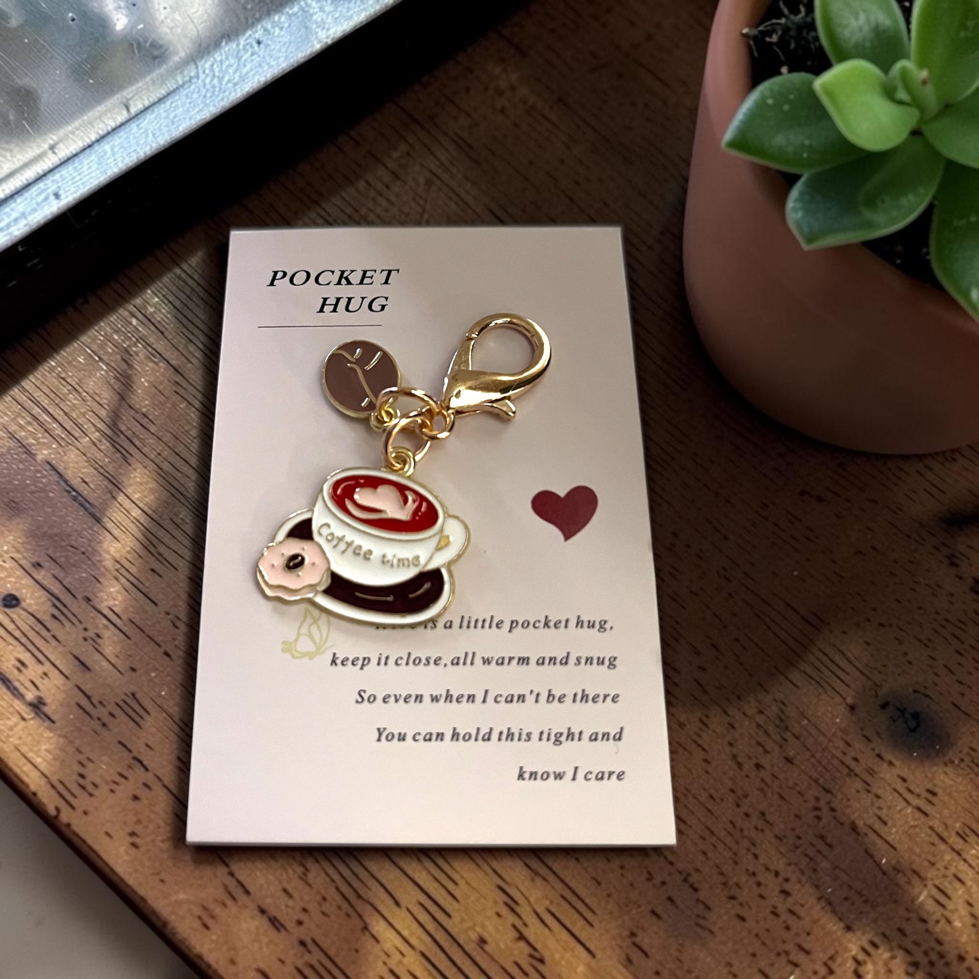 Pocket hug Keychain with a coffee-themed design on a card, placed on a wooden surface, unique keychain, pocket hug in Windsor Ontario. unique gift