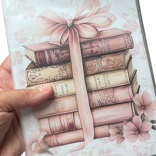 Notebook with clear plastic cover pink stacked books with a pink bow graphic on the front of the notebook